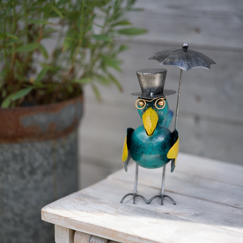 Blå fågel med paraply i hamrad plåt